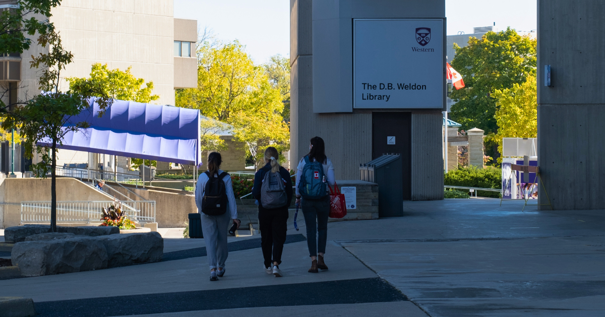 Students walking towards Weldon Library on a sunny day.